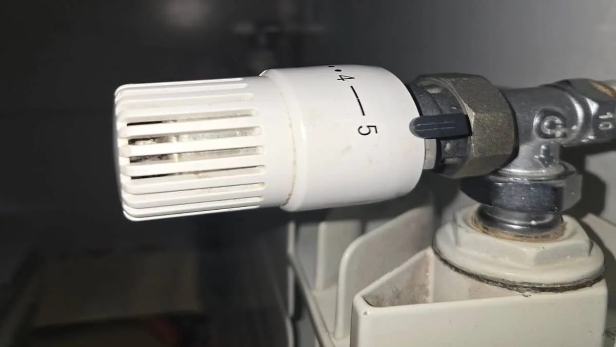 Primo piano di una valvola termostatica su un radiatore, con scala numerata